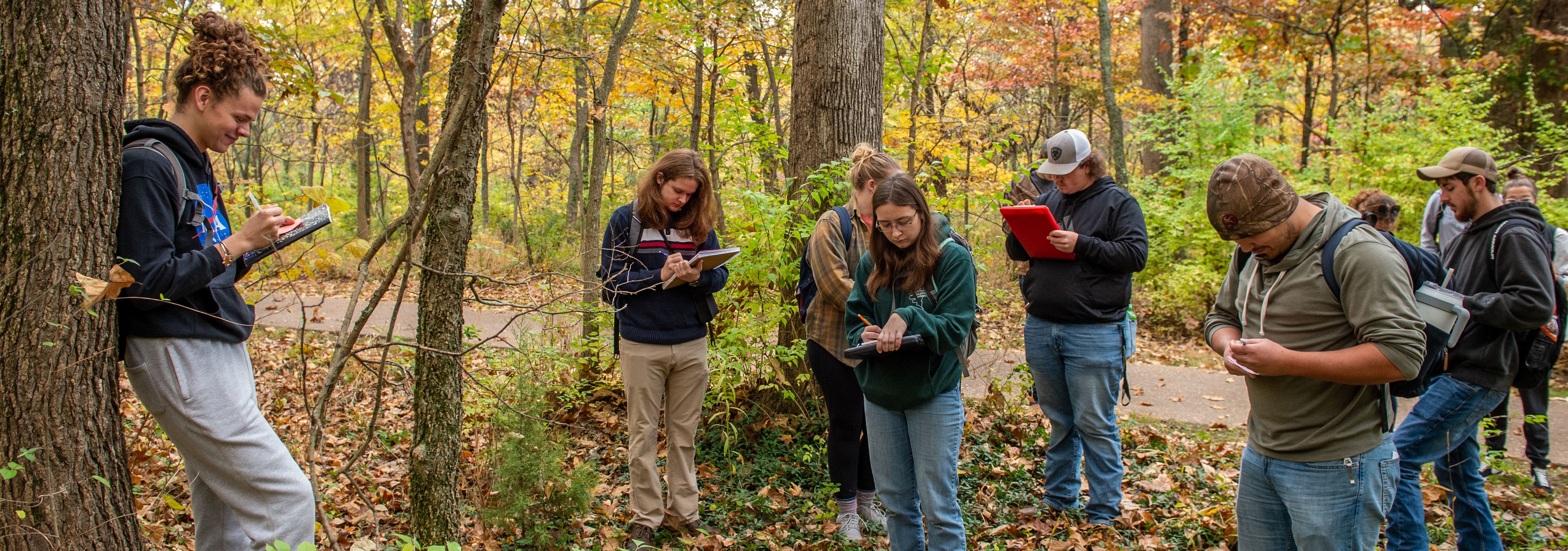 Students gathered in forest reviewing notes